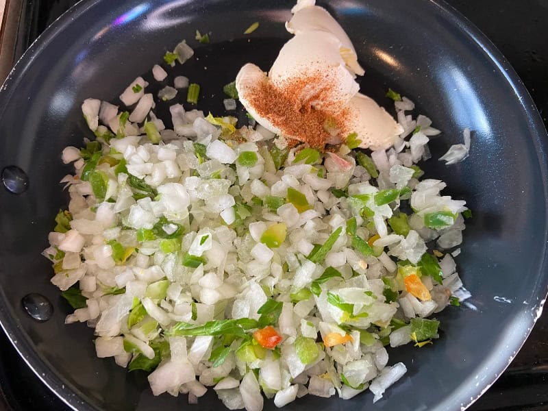 Onion, bell pepper, and celery in a skillet before cooking